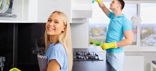una pareja limpiando su cocina