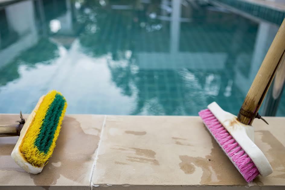 cepillos en una terraza junto a una piscina