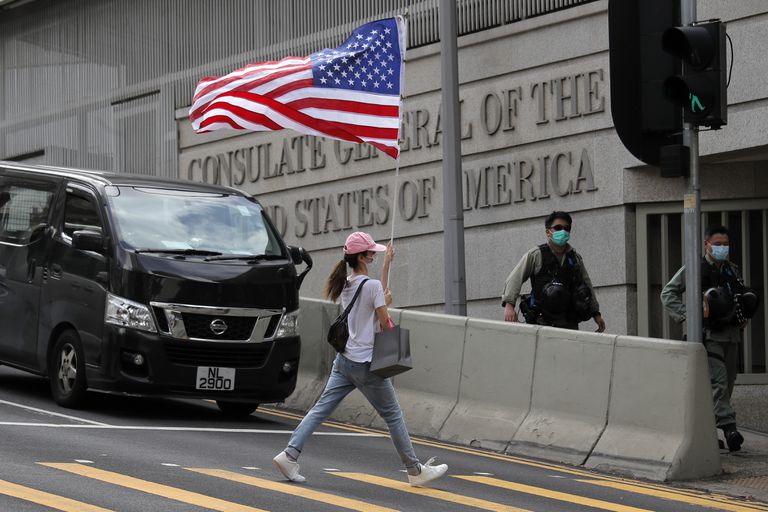 Una manifestante lleva una bandera de EE. UU ante el consulado de ese país en Hong Kong, en una protesta en julio pasado
