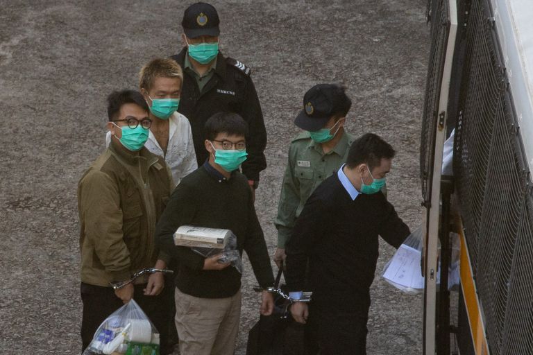 Joshua Wong, en el centro, ha sido trasladado este miércoles a la cárcel tras conocer su sentencia, en Hong Kong.