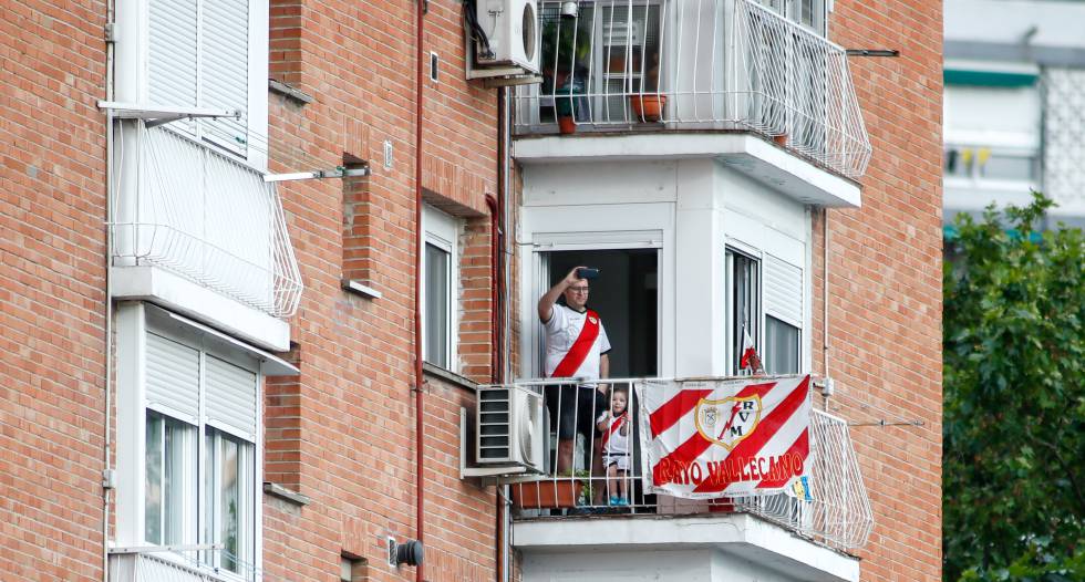 Un aficionado del Rayo Vallecano mira un partido en Vallecas desde su balcón.