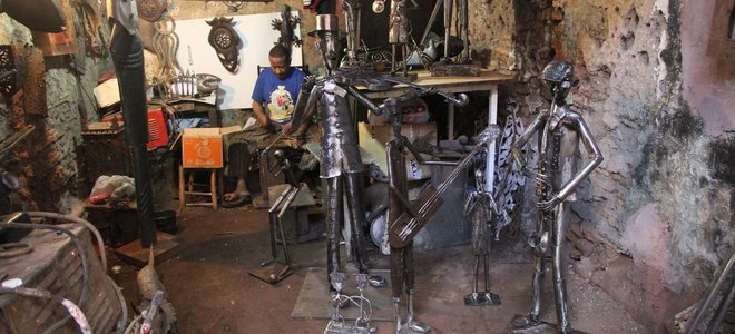 Hombre desplaying estatua de metal elaborada artesanía para la venta