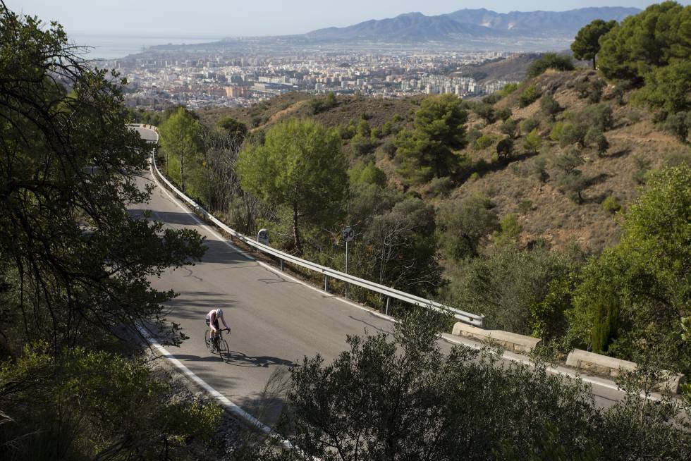 Un ciclista por los Montes de Málaga con vistas de la ciudad al fondo.