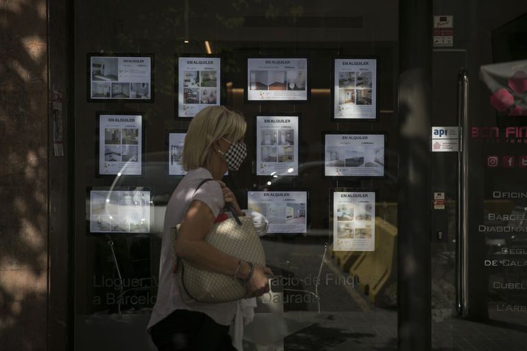 Una mujer pasa frente a una inmobiliaria en Barcelona.