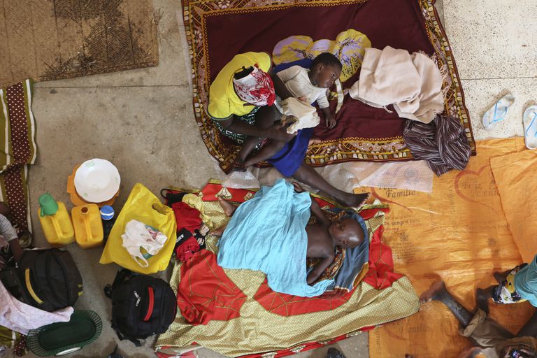 Una madre y sus hijos se preparan para pasar la noche en una iglesia católica de Pemba tras haber huido de su pueblo en el norte de Mozambique, en agosto de 2019.