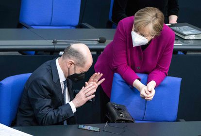 La canciller alemana, Angela Merkel, habla con el ministro de finanzas, Olaf Scholz, durante la sesión del Bundestag de este jueves.