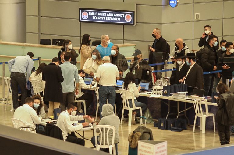 Viajeros recién llegados a Israel esperan a la colocación de pulseras electrónicas de seguimiento, el lunes en el aeropuerto de Tel Aviv.