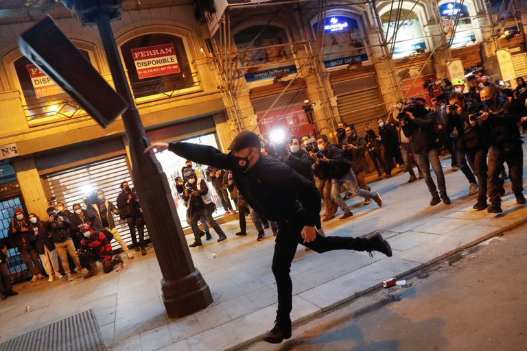 Un manifestante lanza una papelera contra la policía en una protesta contra el encarcelamiento de Pablo Hasél en Madrid el 17 de febrero.