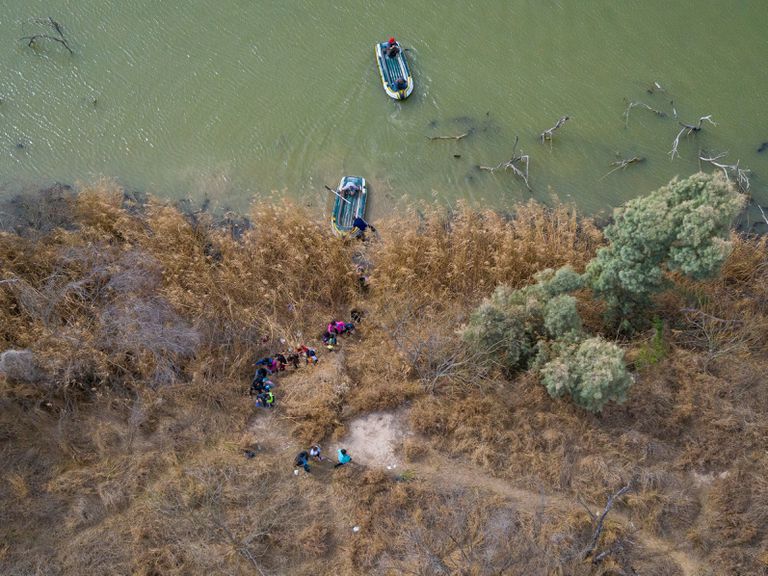 Familias y menores migrantes cruzan el río Bravo hacia Texas.