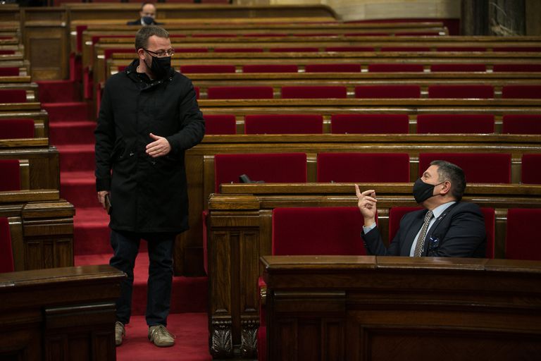 El diputado de la CUP, Vidal Aragones (izq.) conversa con el consejero de Interior, Miquel Sàmper, en el Parlament.