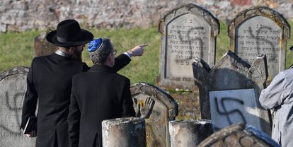 Dos hombres señalan las tumbas destrozadas en diciembre de 2019 en el cementerio judío Westhoffen cerca de Estrasburgo (Francia).