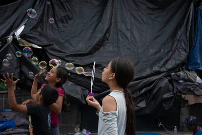 Tres niñas juegan en el campamento de Reynosa.