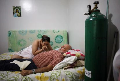 Una mujer acompaña a su padre enfermo de covid en su casa en Manaos (Brasil), en enero de 2021.
