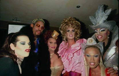 Dennis Rodman posa rodeado de travestis. Lo hizo en un tiempo en que  estar rodeado de travestis no era una estampa moderna y aceptable, sino más propia del lumpen y reservada a homosexuales.