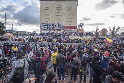 Multitud de personas, en su mayoría jóvenes frente al monumento a los Héroes en Bogotá.