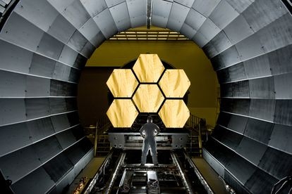 Un operario examina parte de los espejos del telescopio espacial 'James Webb'.