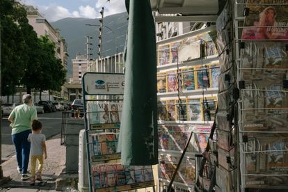 Peatones pasan frente a un kiosco en Caracas que antes vendía periódicos y ahora solo vende revistas.