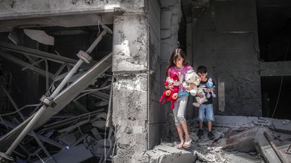 Niños palestinos rescatan juguetes de su casa, que resultó gravemente dañada por los ataques aéreos israelíes, en la Torre Al-Jawhara en Gaza, el pasado 17 de mayo.