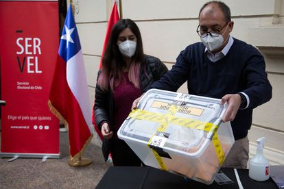 Trabajadores electorales sostienen una caja con votos, el pasado 13 de marzo en Santiago de Chile.