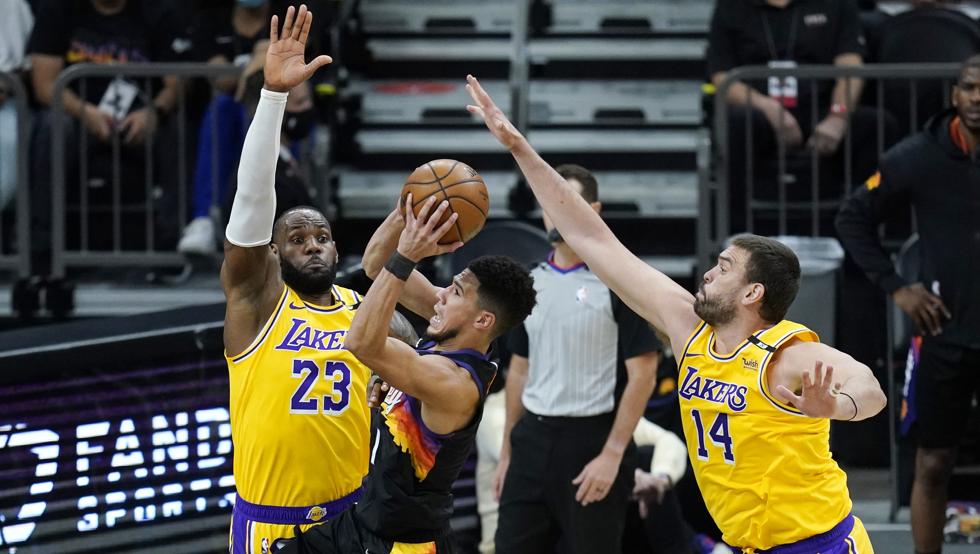 Devin Booker intenta anotar por encima de LeBron James y Marc Gasol durante la victoria de Los Angeles Lakers sobre los Phoenix Suns en el segundo partido de la eliminatoria de primera ronda de los playoffs 2021.