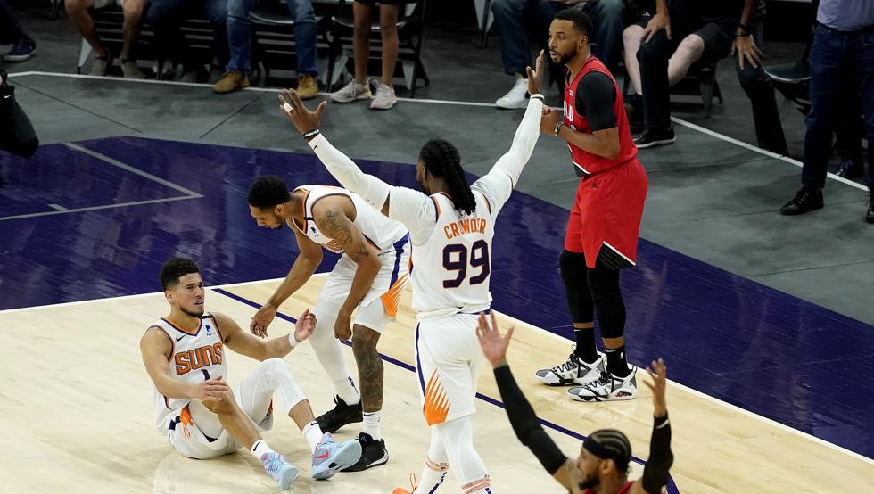 Devin Booker recibe el apoyo de Cameron Payne y Jae Crowder tras recibir la falta de Norman Powell que decidió con dos tiros libres la victoria de los Phoenix Suns sobre los Portland Trail Blazers.