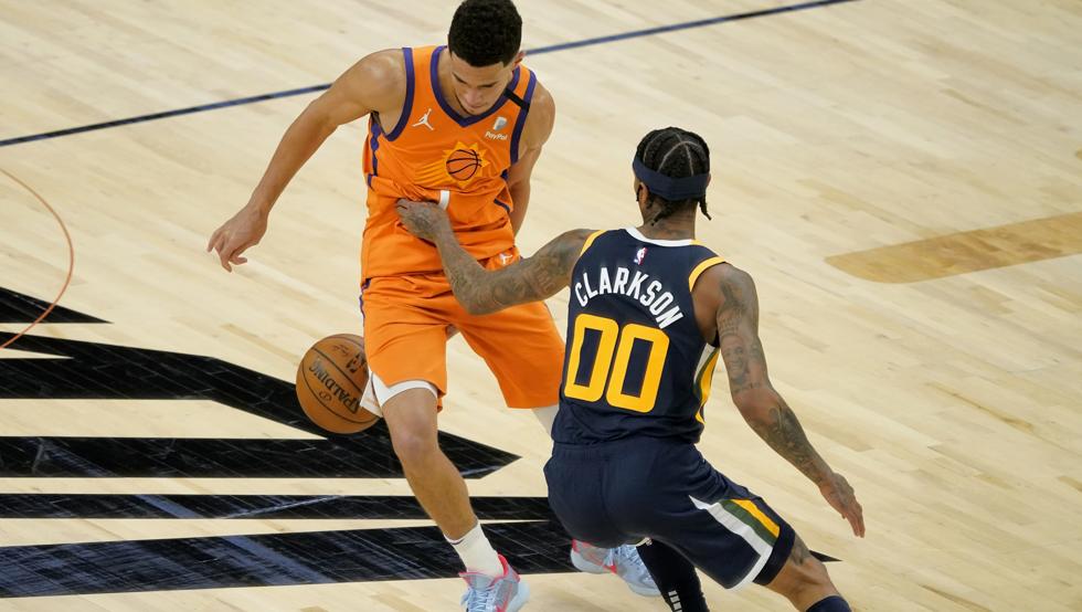 Devin Booker y Jordan Clarkson disputan un balón en el enfrentamiento entre los Phoenix Suns y los Utah Jazz que dio el liderato de la NBA al conjunto de Arizona.