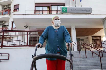 Una anciana sale de una residencia sevillana durante el segundo día en que se les permitió salir a pasear, en febrero.