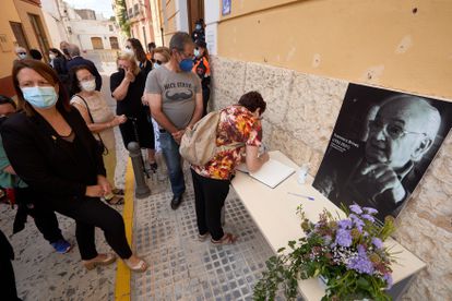 Una vecina de Oliva escribe en el libro de condolencias de la capilla ardiente con los restos mortales del poeta Francisco Brines.