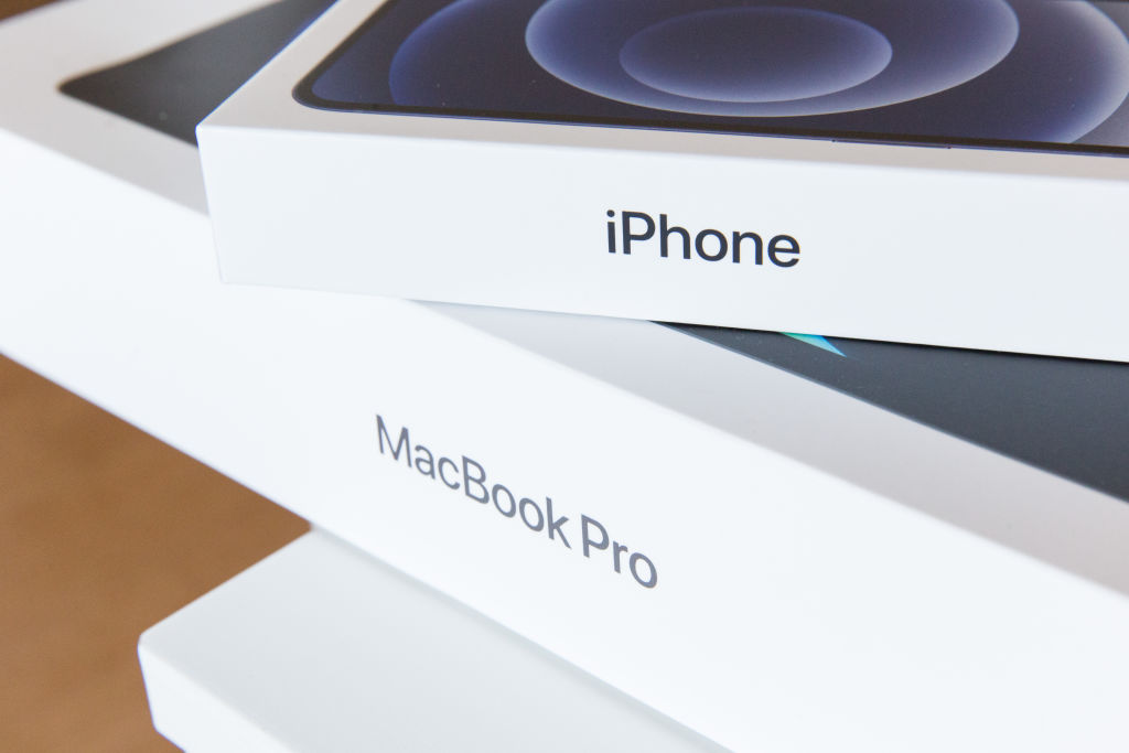 un nuevo paquete de iPhone 12 sobre un paquete de MacBook Pro.