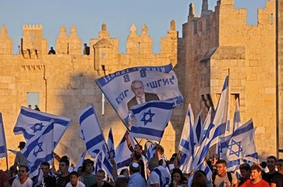 Israelíes ondean banderas fuera de la Puerta de Damasco en la Ciudad Vieja de Jerusalén, el 15 de junio de 2021, celebrando el aniversario de la ocupación israelí de 1967 de Jerusalén Este.