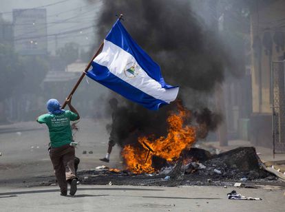 Un joven corre con una bandera en Masaya (Nicaragua) durante una protesta en 2018.