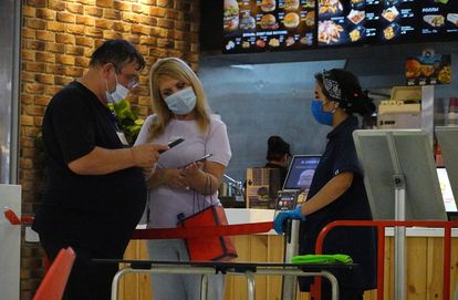 Un empleado revisa el código QR de una ciudadana en un establecimiento de comida rápida en Moscú, este lunes. 