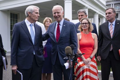 Joe Biden anuncia el acuerdo sobre el plan de infraestructuras, rodeado por los senadores que lo negociaron, este jueves en la Casa Blanca.