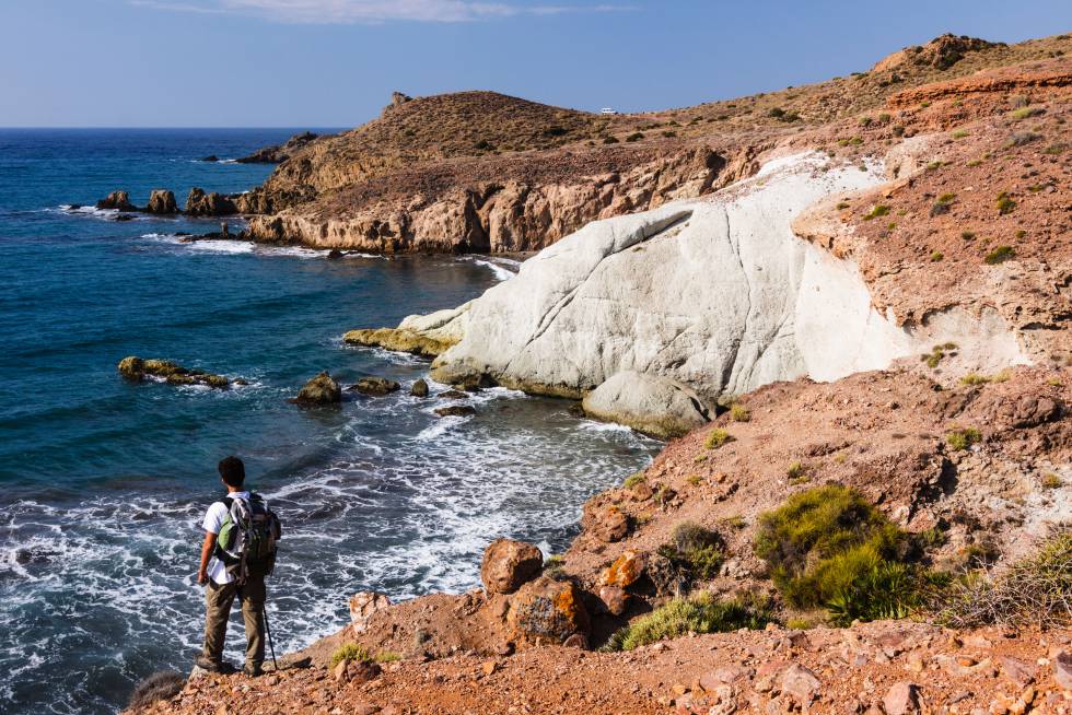 Un senderista se asoma a una de las calas del parque natural de Cabo de Gata-Níjar, en Almería.