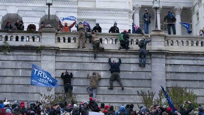 Los partidarios del presidente Donald Trump escalando el muro oeste del Capitolio de Estados Unidos en enero.
