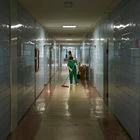 El equipo de limpieza, con bata verde y guantes amarillos, es el único que salen al pasillo en el hospital de Svitlodars’k.