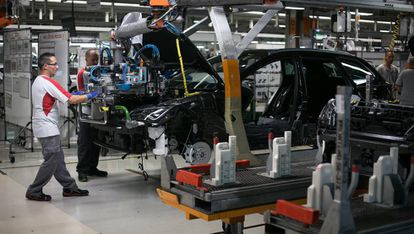 Dos operarios participan en el ensamblaje de un Seat Leon en Martorell (Barcelona).