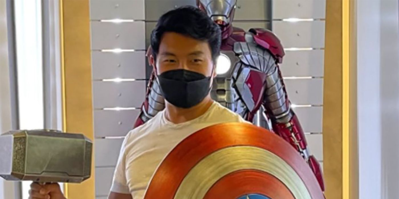 Simu Liu de Shang-Chi posa con el escudo del Capitán América y Mjolnir