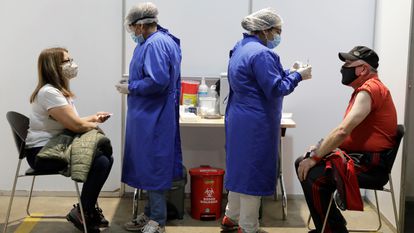 Dos personas reciben la vacuna contra la covid-19 en el centro de vacunación más grande de Colombia.