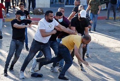 Policías palestinos de paisano detienen a un manifestante, el domingo en Ramala.