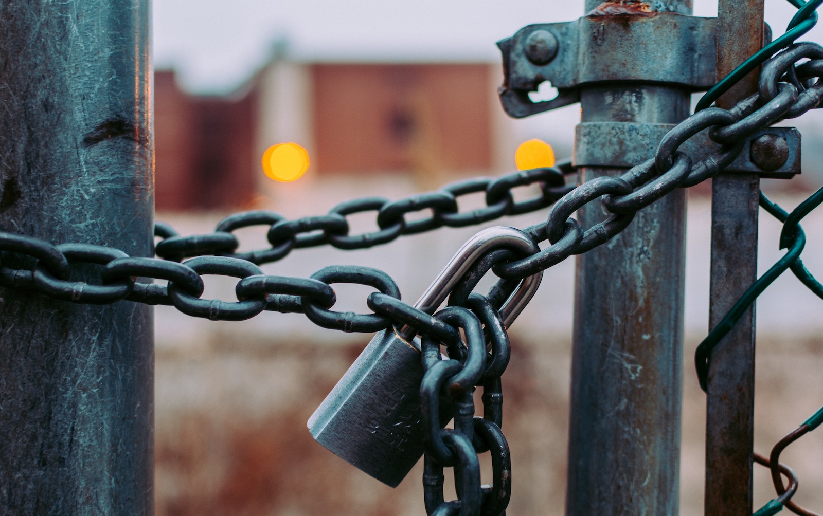 Una cadena con candado sostiene una cerca o puerta cerrada