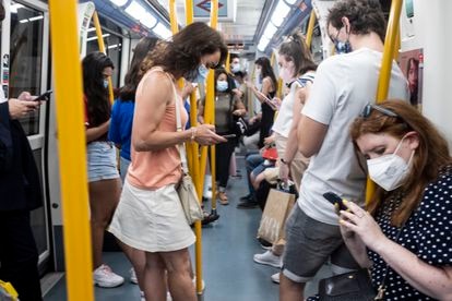 Gente mirando el móvil en un vagón del metro de Madrid, este jueves.