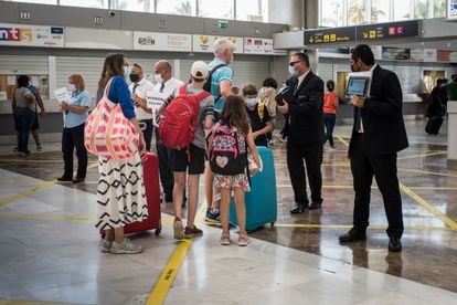 Dos conductores recogen a una familia inglesa, este lunes en el Aeropuerto de Tenerife Sur.