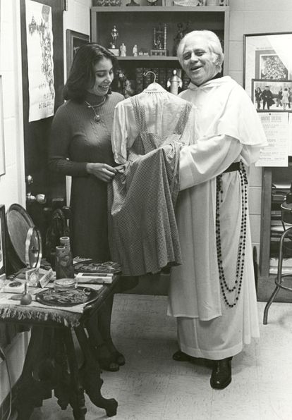 Una fotografía divulgada por la Universidad Católica de América donde aparece el padre Gilbert Hartke y la estudiante Carol Pearson mientras sostienen el vestido de Dorothy en 'El mago de Oz' de 1939.
