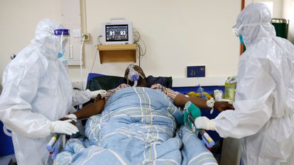 Personal médico con equipo de protección atiende a un paciente con covid en la UCI del hospital de Machakos, en Kenia, a mediados de junio.