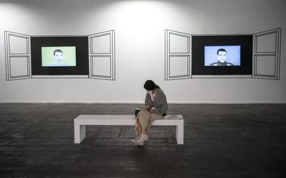 Una mujer sentada frente a obras de Alfredo Dufour en la nueva sección Remitentes, que concentra a distintas galerías latinoamericanas que no han podido desplazarse a la feria por las restricciones.