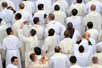 Sacerdotes sacan fotos con sus móviles durante la misa oficiada por el papa Francisco antes de la apertura de la Puerta Santa en 2019.