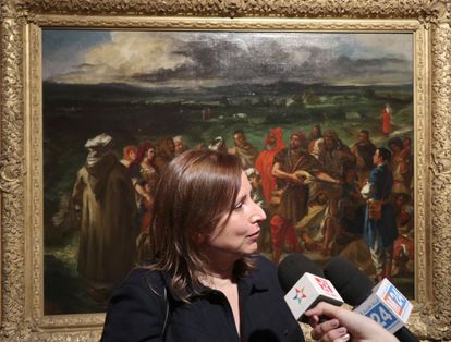 La comisaria de la exposición y directora del Museo Delacroix, Claire Bessède, atiende a los medios con un cuadro de la exposición detrás. 