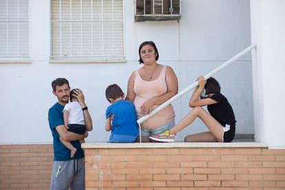 José Amores y Aurora Gutiérrez, este viernes junto a sus tres hijos a las puertas de su bloque, en La Rinconada (Sevilla). 