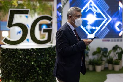 Un hombre pasa por delante de un anuncio de 5G, el pasado junio en el MWC de Barcelona.